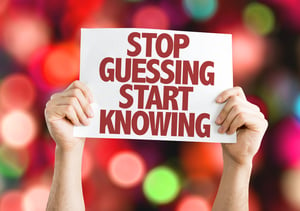 Stop Guessing Start Knowing placard with bokeh background